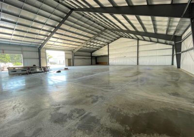 a large warehouse with concrete floors and a roof