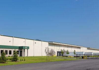 a large warehouse with a green roof and white walls
