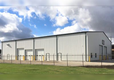a large warehouse with a fence and a sky