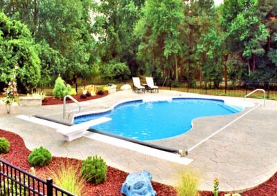 a swimming pool with a deck and landscaping