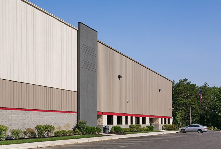 a large warehouse with a parking lot and a car